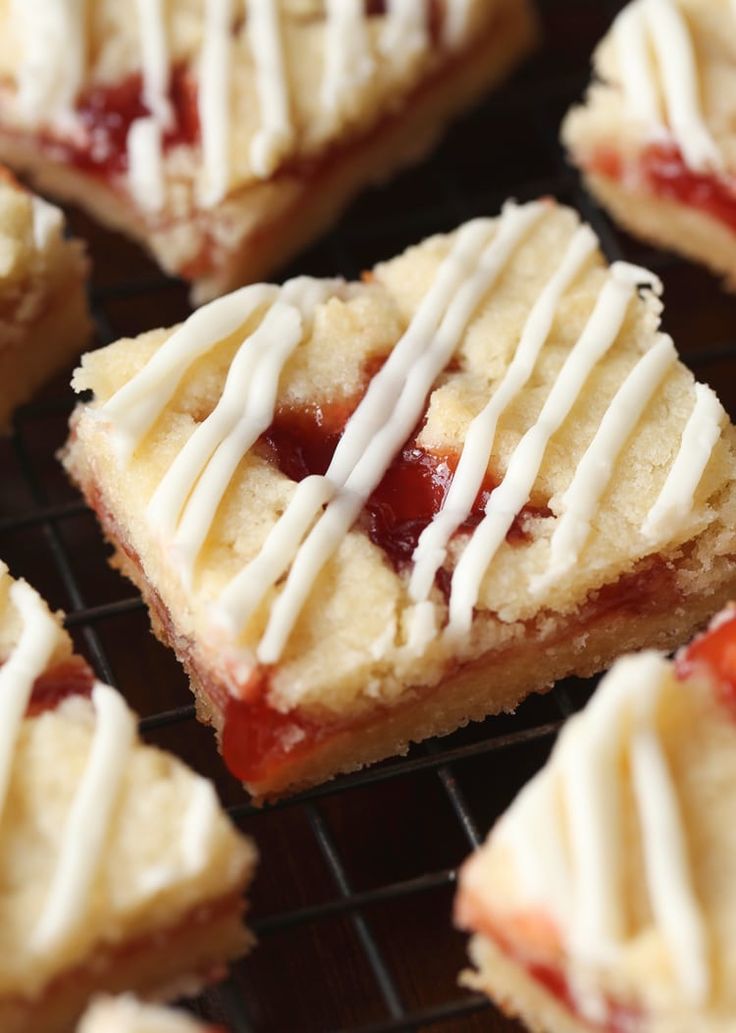 strawberry shortcakes with white icing on a cooling rack, ready to be eaten