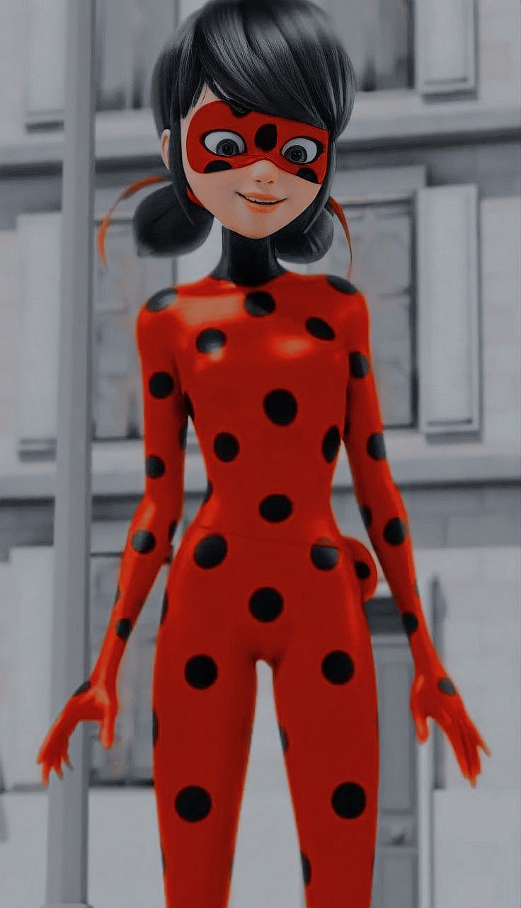 a woman in a red and black polka dot suit standing next to a pole with her hands on her hips