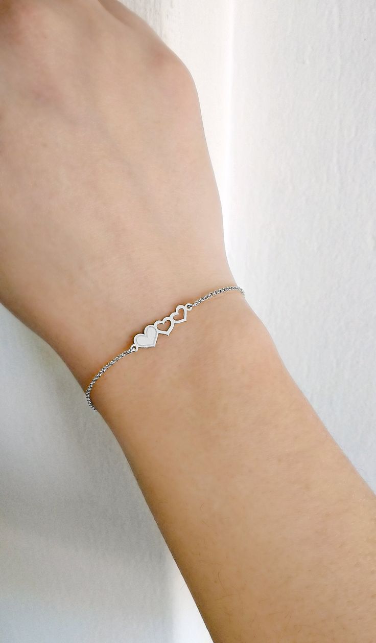 "14K Gold Triple Heart Bracelet, 9K Solid gold bracelet, Dainty gold bracelet, Love bracelet, Gift for her, Hearts bracelet, Rose Gold bracelet, 9K Gold bracelet, Delicate gold bracelet, FREE EXPRESS SHIPPING Beautiful and delicate bracelet with a triple heart charm made in 14K or 9K solid gold. \"One is loved because one is loved. No reason is needed for loving.\" -- Paulo Coelho Whisper...Love is in the air! -------------------------------------------------- D E T A I L S 14K Solid Gold or 9K White Gold Heart Charm Bracelet For Anniversary, White Gold Heart Bracelet With Charm For Anniversary, White Gold Jubilee Bracelet For Valentine's Day, Dainty Sterling Silver Bracelet For Valentine's Day, Dainty Double Heart Bracelets For Mother's Day, Elegant Heart Shaped Bracelets For Anniversary, Sterling Silver Heart Bracelet With Jubilee Style For Anniversary, Elegant Sterling Silver Name Bracelet For Valentine's Day, Elegant Double Heart Charm Bracelet For Anniversary