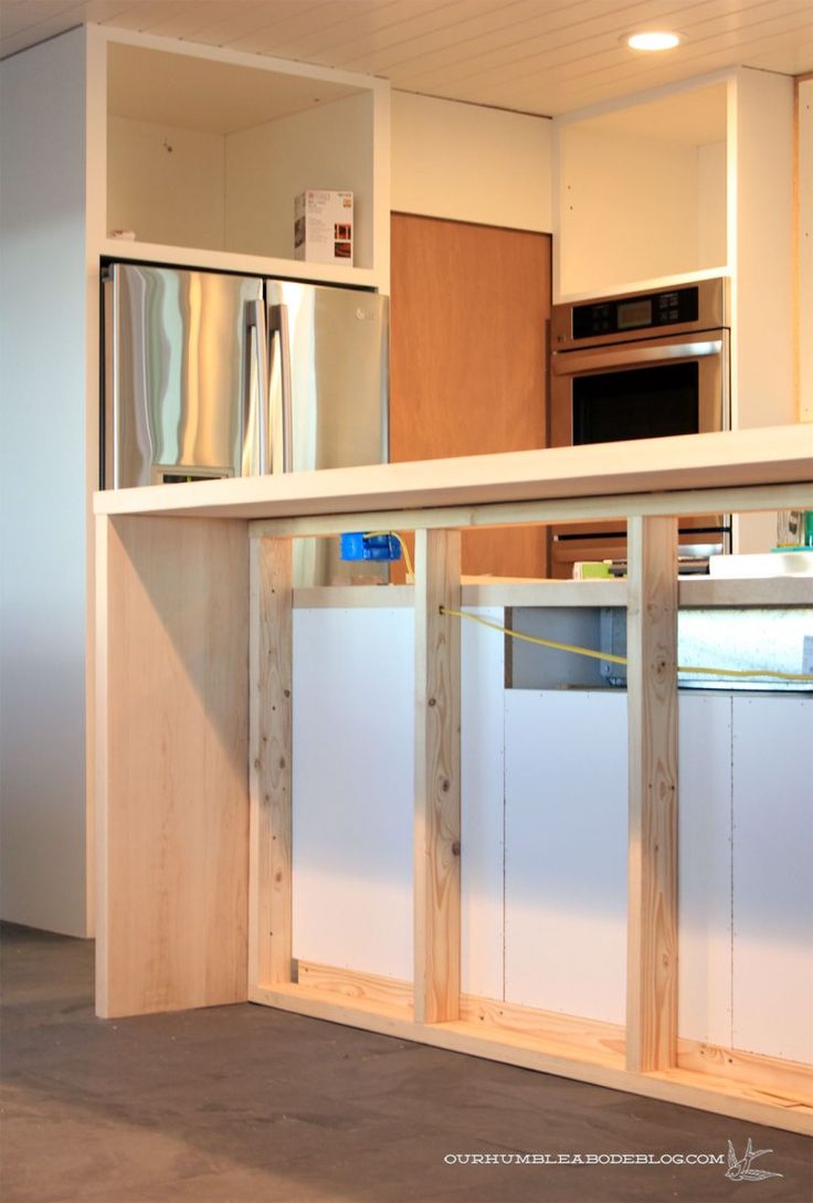 an unfinished kitchen with white walls and cabinets