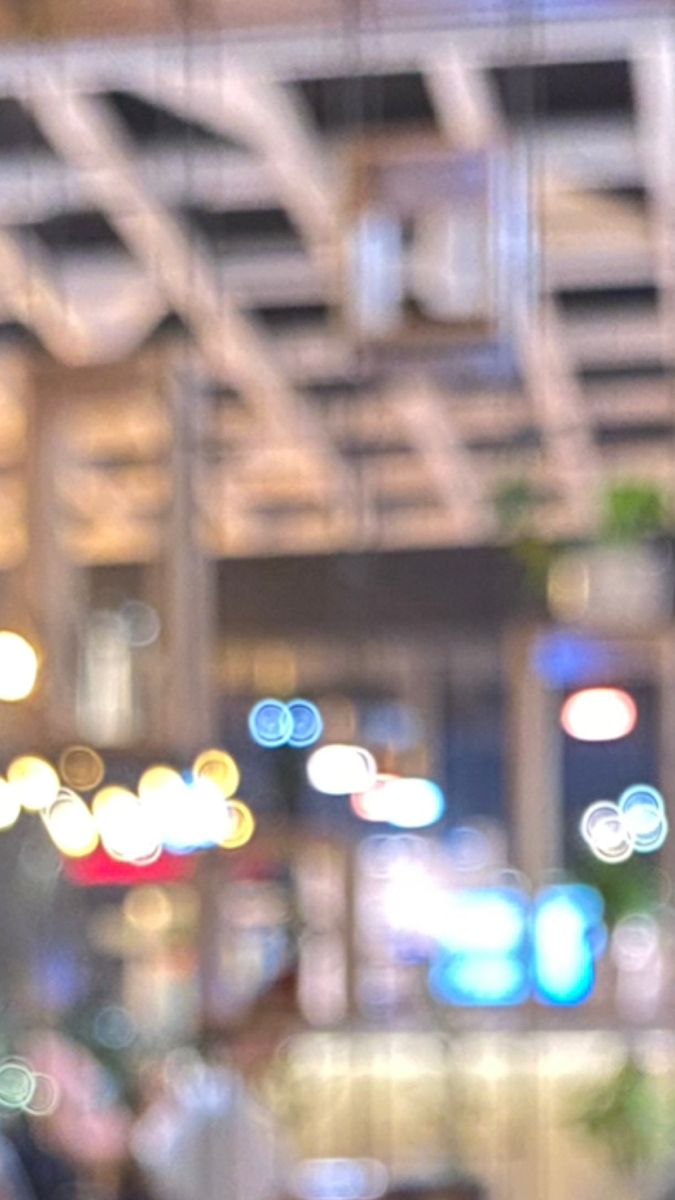 blurry image of city lights and people in the background, taken from inside a building