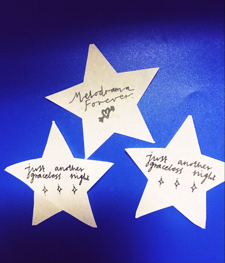 three white stars with writing on them sitting in the middle of a blue tablecloth