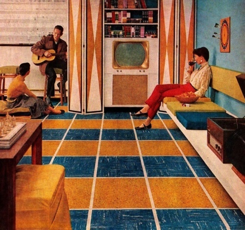 an old photo of people playing guitar in a living room with orange and blue striped walls