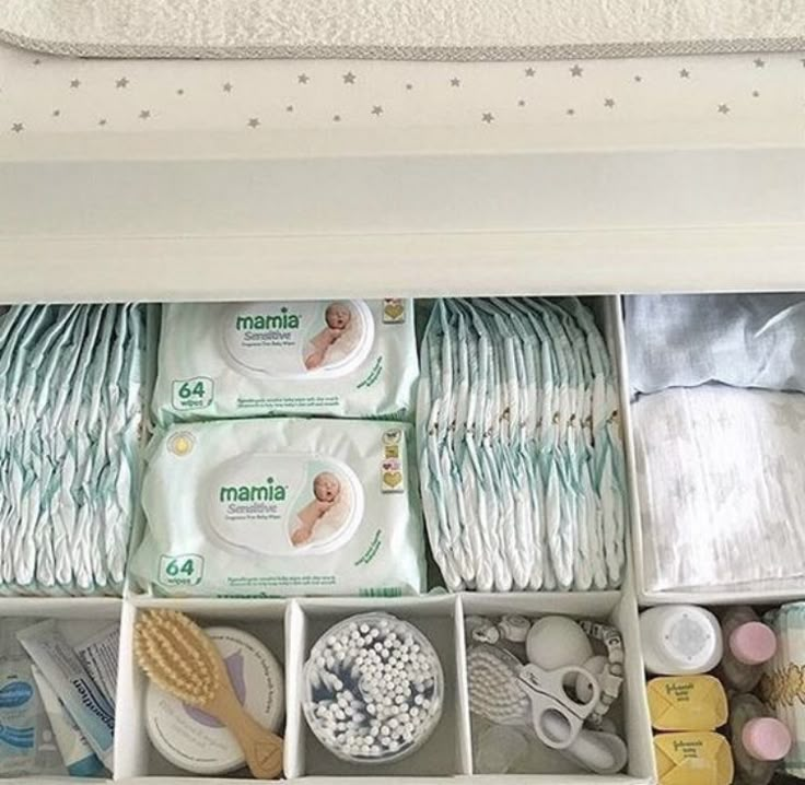 an organized drawer filled with diapers and baby wipes, napkins, and other items