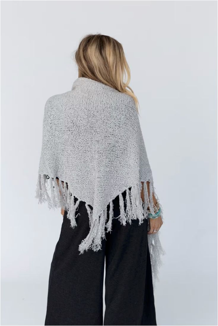 Drape yourself in the Moon Shadows Ruana Wrap and feel stylishly boho from day to night! This cozy-knit wrap features a loose and flowy silhouette, a beautiful triangular shape, and adorable tassel trim for a unique and versatile look. Infuse your wardrobe with some boho flair! Details: One size: 33 1/2"W x 86"L 100% Acrylic Hand wash cold, Lay flat to dry Import Casual One Size Poncho With Fringe, Casual One-size Poncho With Fringe, One Size Knit Poncho With Fringe, Bohemian Knit Poncho With Fringe, One Size Beach Shawl With Fringe, Casual Poncho With Tassels For Festivals, Casual Festival Poncho With Fringe, Casual Wrap Poncho One Size, Beach Shawl With Tassels One Size