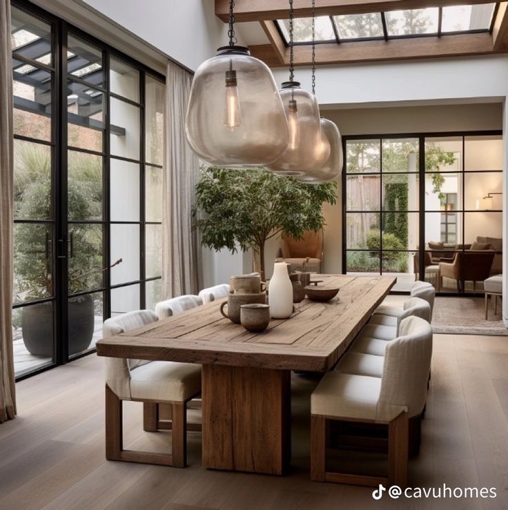 a dining room table with chairs and lights hanging from it's centerpieces