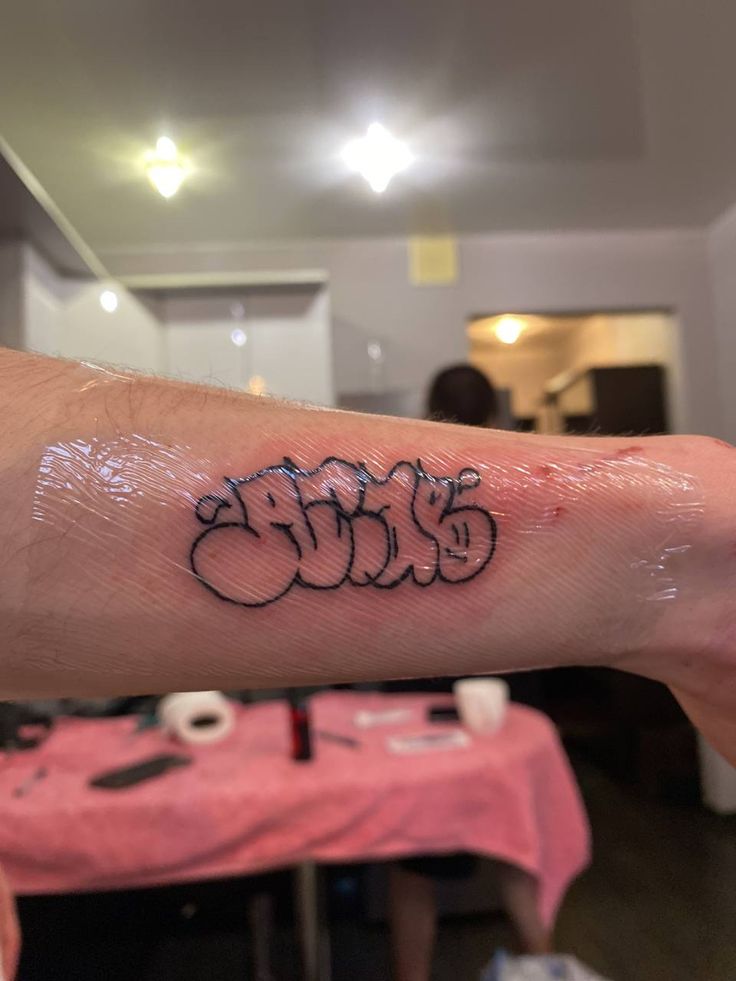 a person's arm with graffiti on it and the word love written in black ink