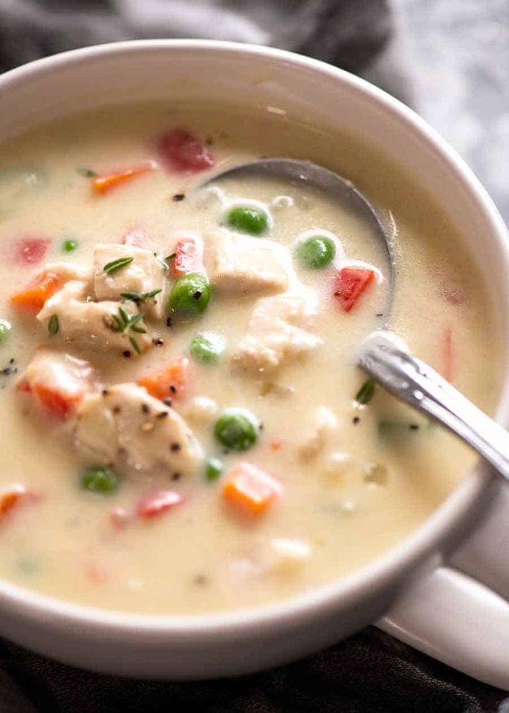 a white bowl filled with chicken and vegetable soup