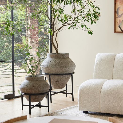 two large vases sitting on top of a table next to a white couch in a living room