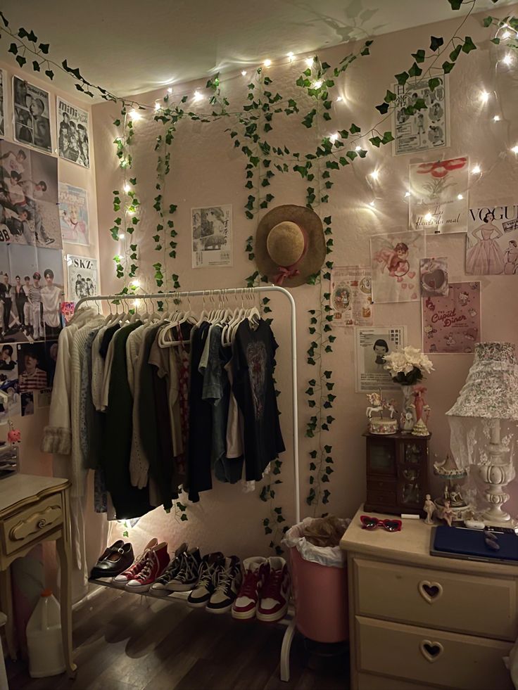 a bedroom with lots of clothes hanging on the wall and lights strung from the ceiling