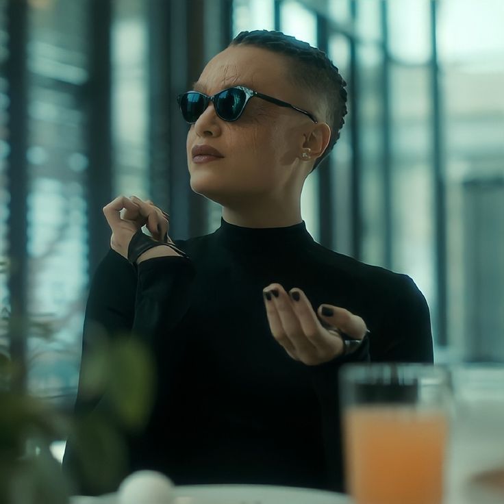 a woman wearing sunglasses sitting at a table