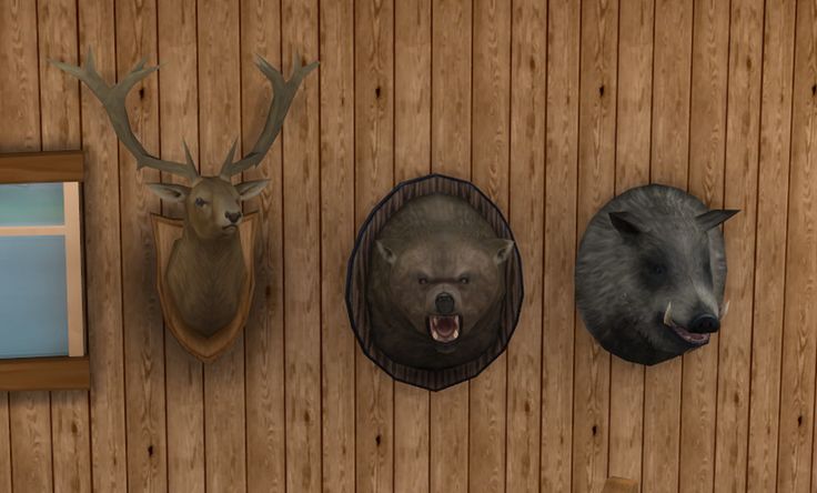 three animal heads mounted to the side of a wooden wall