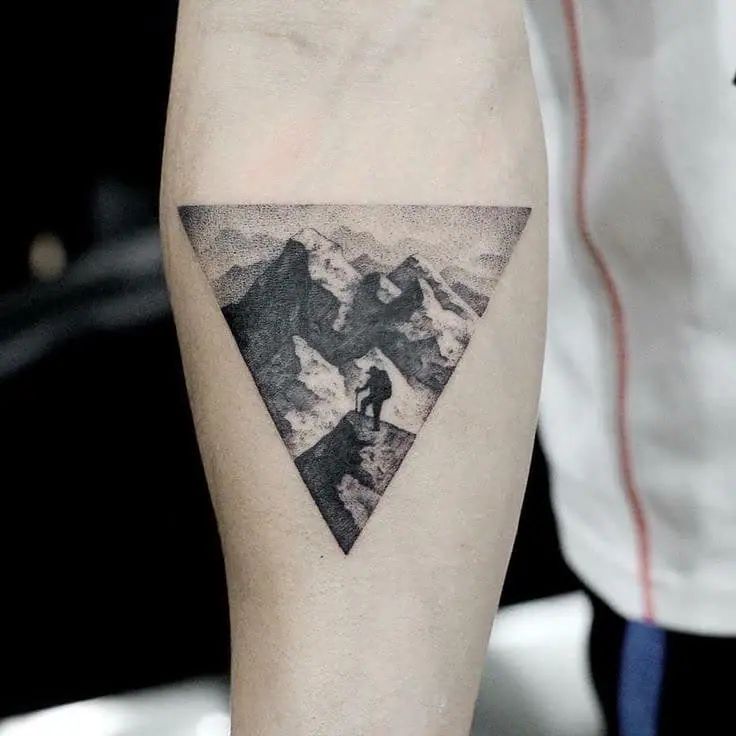 a man's arm with a triangle tattoo on it