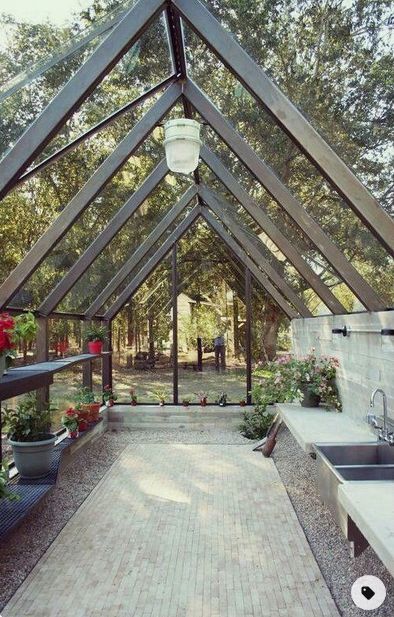 the inside of a building that has some plants in it and flowers on the outside