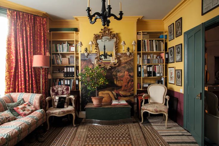 a living room filled with furniture and bookshelves next to a painting on the wall