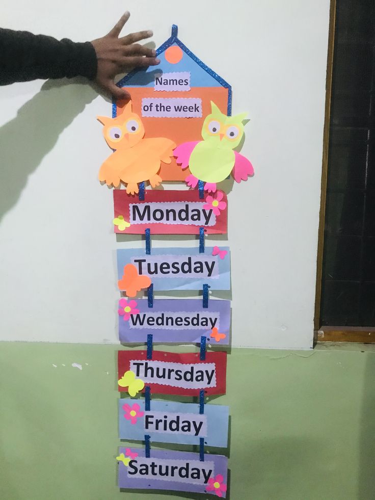 a stack of days of the week cards with hands on top of each card and one hand reaching for it