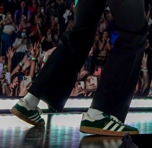 a person standing on top of a stage with their feet up in front of the audience