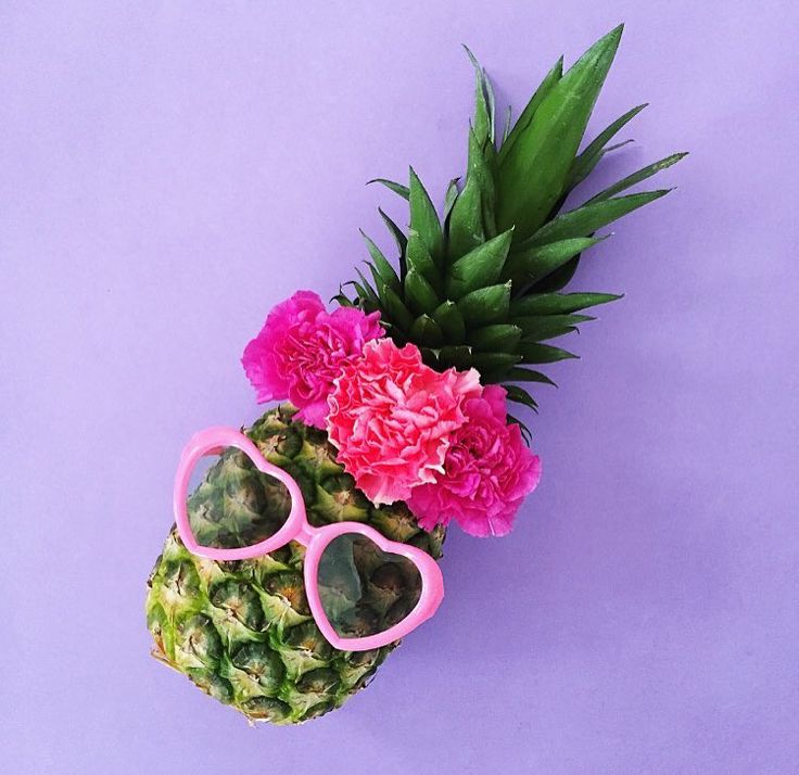 a pineapple with pink sunglasses and flowers