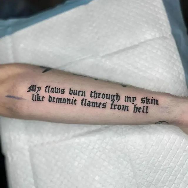 a person with a tattoo on their arm that says, my tattoos burn through my skin like demonic flames from hell