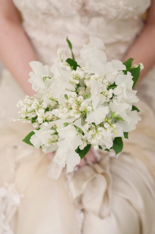 a bridal holding a bouquet of white flowers