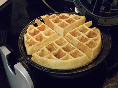 two waffles sitting on top of a black stove next to an electric blender