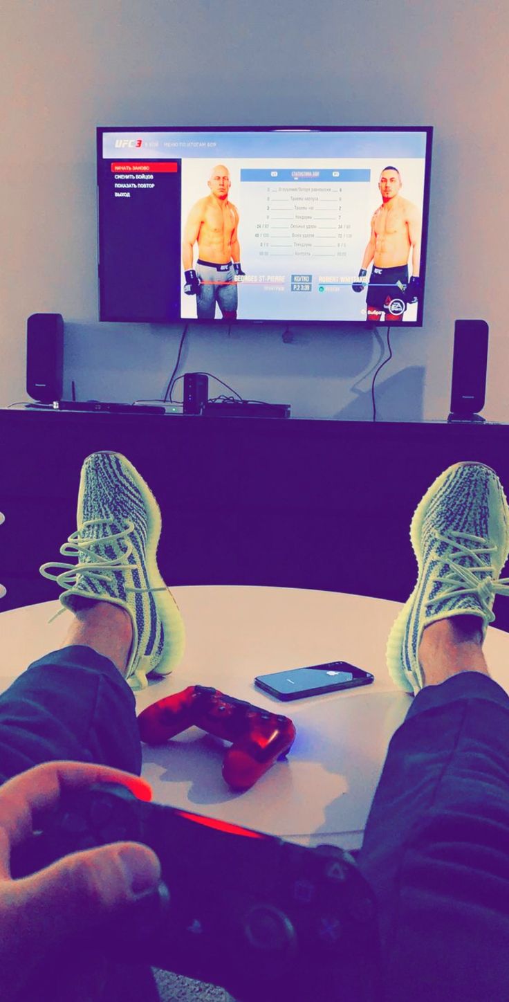 a person with their feet up on a table in front of a flat screen tv