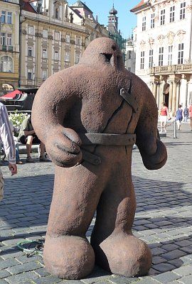 a giant teddy bear statue on the street in front of some buildings with people walking by