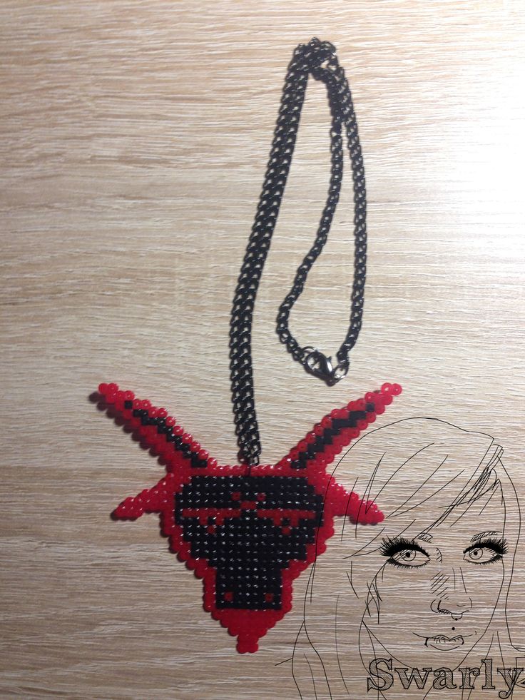 a woman's face on a wooden surface with a black and red beaded necklace