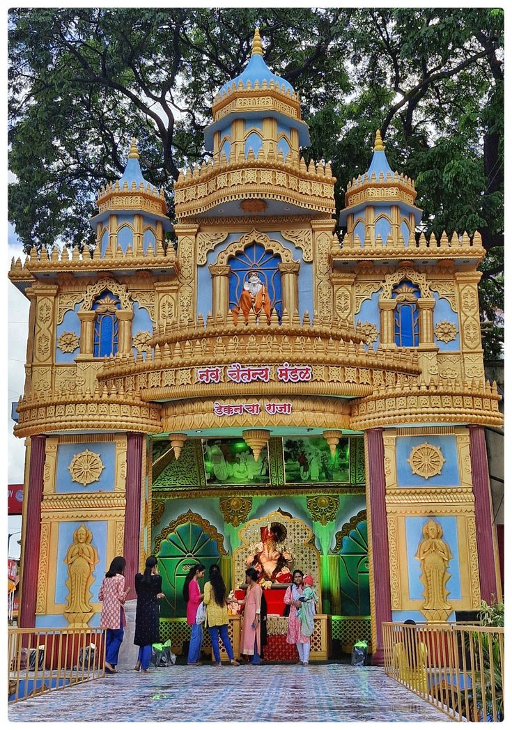 people are standing in front of an elaborately decorated building with statues on the sides