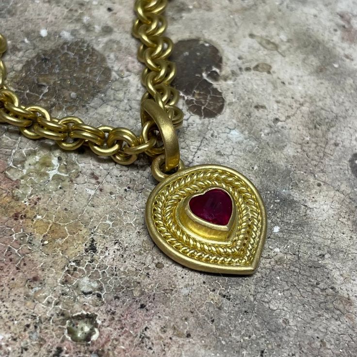 A unique take on a classic design, this pendant features a heart-shaped ruby framed by braids of gold. A very special gift for someone who holds your heart! Please note that pendants are sold separately from chains. 20K Peach Gold Heart-shaped ruby, 1.10 cwt Style Number: PP62BRHEART Hand fabricated in our New York City design atelier & workshop Yellow Gold Ruby Heart Pendant Necklace, Traditional Yellow Gold Jewelry For Valentine's Day, Ruby Heart Charm Pendant Necklace, Traditional Heart Charm Pendant Jewelry, Gold Ruby Heart Pendant Jewelry, Traditional Heart Charm Jewelry For Valentine's Day, Traditional Pendant Necklace For Valentine's Day, Traditional Valentine's Day Pendant Necklace, Design Atelier