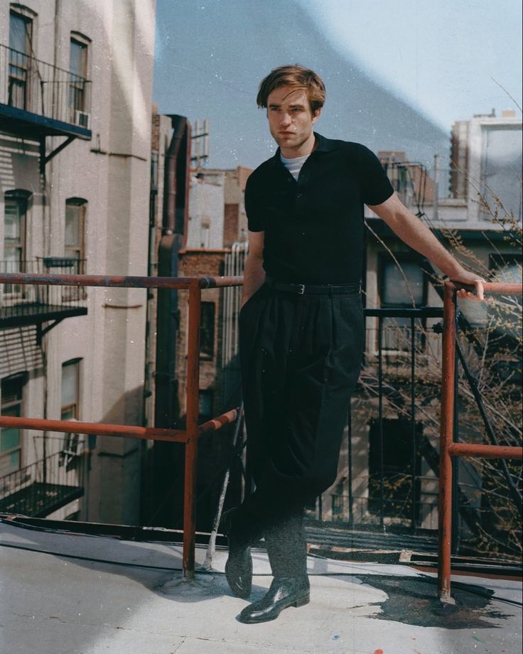 a man standing on top of a roof next to tall buildings