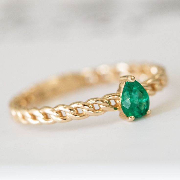 a gold ring with a green stone on it