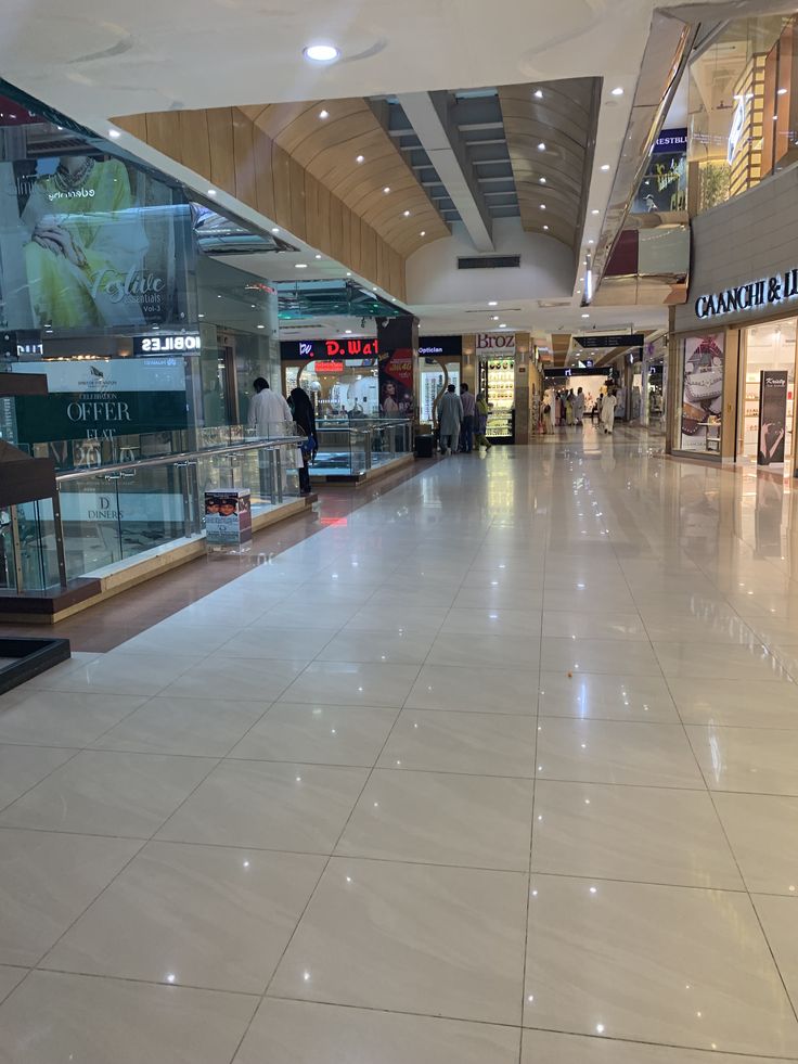 an empty shopping mall with people walking around