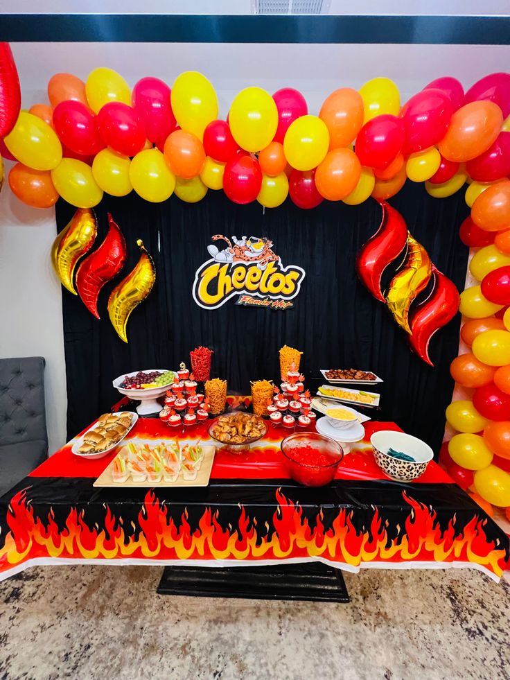 a table topped with lots of food and balloons