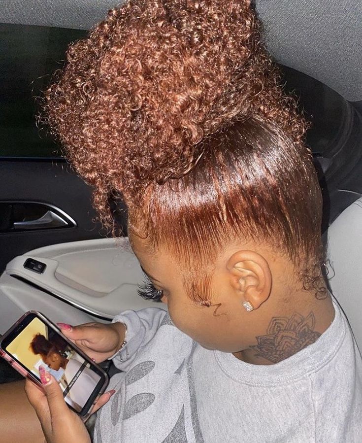 a young woman sitting in the back seat of a car looking at her cell phone