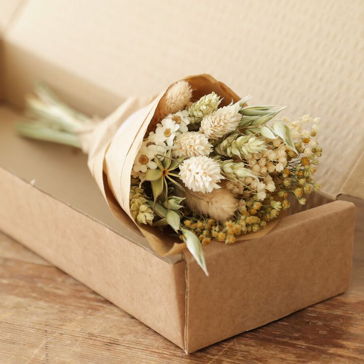 an open box with flowers in it on a table