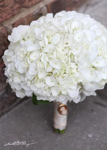 a bouquet of white flowers sitting on top of a sidewalk