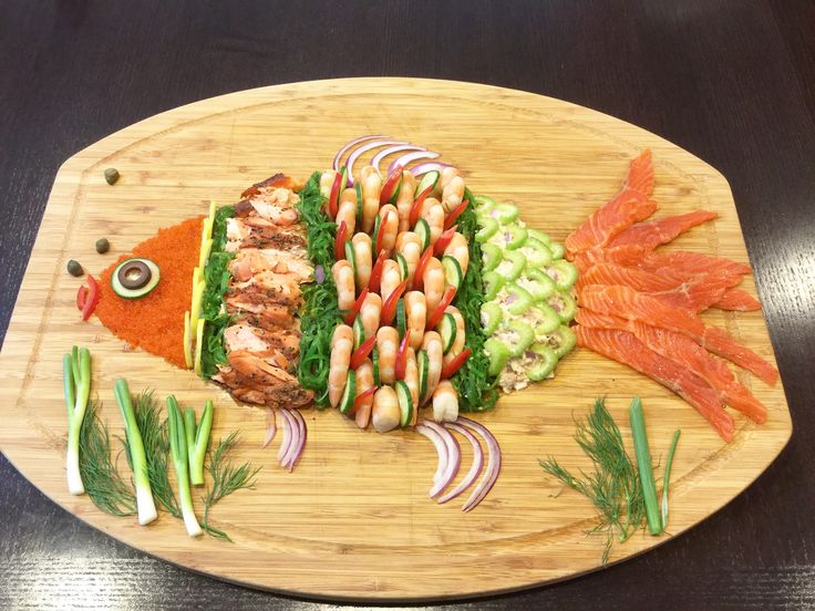 a wooden cutting board topped with lots of different types of food on top of it