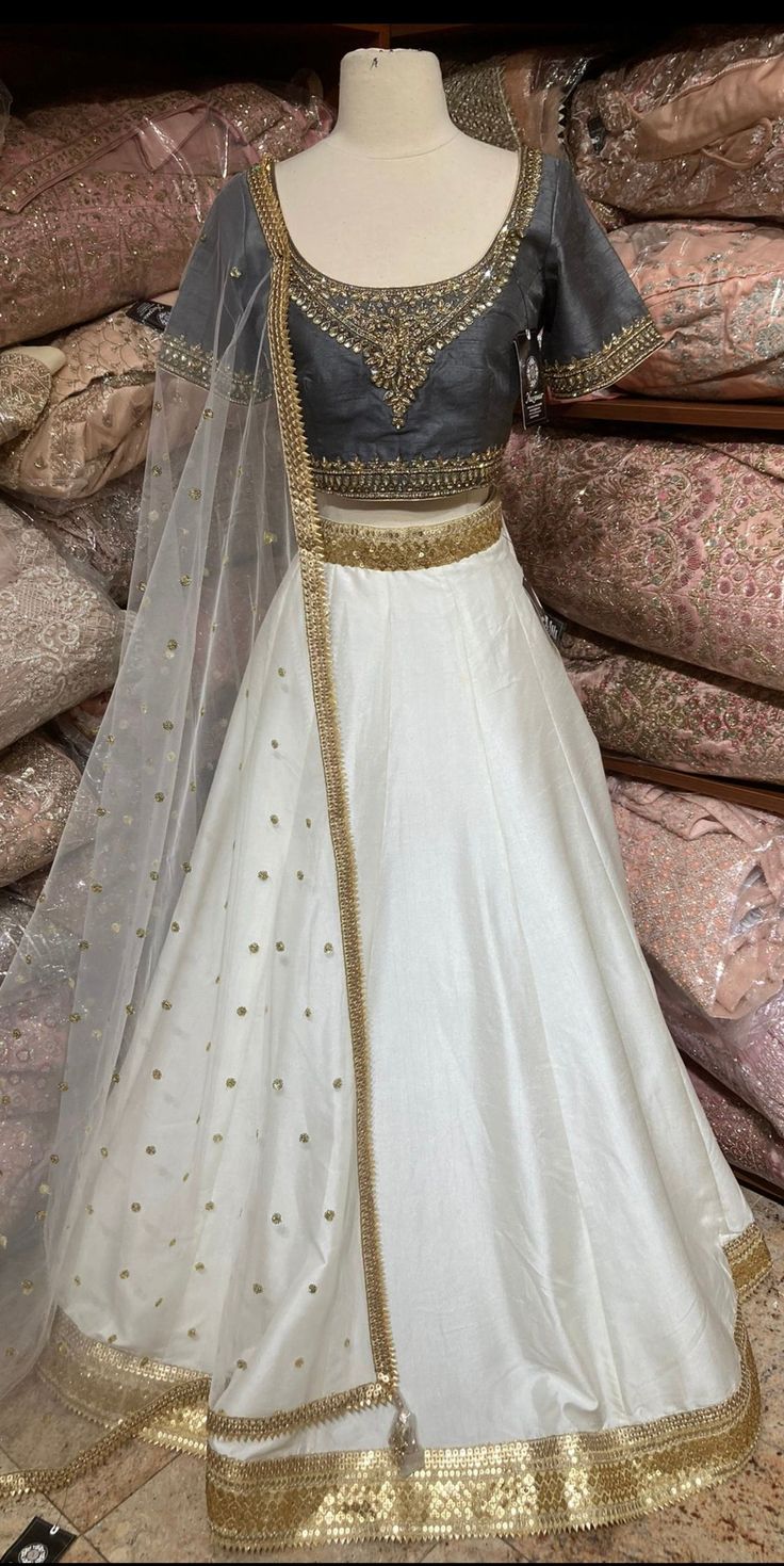 Jasmine white plain lehenga with gold border teamed with contrasting grey intricate in kundan, cut dana and stone work blouse and net dupatta. Fabric: Silk Occasion: Wedding Ceremony or Reception. WASH CARE INSTRUCTIONS - Please Dry clean only when it is applicable. Slight color variation is possible due to digital photography. This outfit can be customized in multiple colors and specific to client measurements. 120 days of production time is required and are for bulk orders only!Order are proce White Kundan Lehenga With Cutdana, White Cutdana Lehenga For Reception, White Choli With Cutdana For Reception, Designer White Choli With Mirror Work, Elegant White Choli For Navratri, Designer Wear White Choli With Mirror Work, White Raw Silk Salwar Kameez For Reception, Elegant White Kundan Choli, White Lehenga For Reception And Navratri