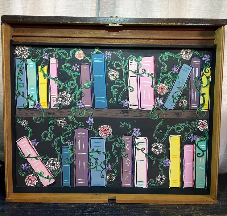 a painting of books on a shelf with flowers and vines painted on the bookcase