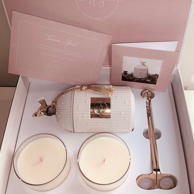 two white candles are sitting in a box