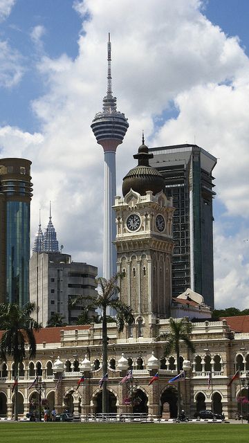 a large building with a clock tower in the middle of it's front yard