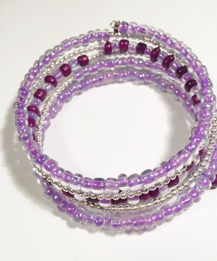 three strand bracelets with purple beads and silver spacers on white background, closeup