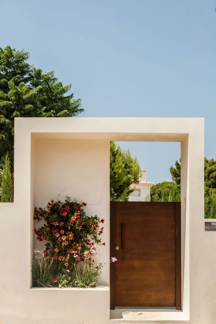 an entrance to a house with flowers growing out of it