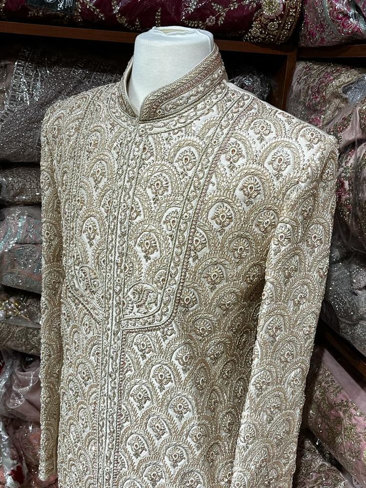 This beige white royal sherwani is brought into limelight with fine jaal embroidered coat enhanced with resham, pearl ,stone & cut dana work. The coat is styled with matching churidar pants. Size:40,42,44 Occasion: Wedding Ceremony or Reception WASH CARE INSTRUCTIONS - Please Dry clean only when it is applicable. Slight color variation is possible due to digital photography. Ready to Ship! Elegant Raw Silk Sherwani With Intricate Embroidery, Elegant Jamawar Sherwani With Intricate Embroidery, Designer White Churidar With Naqshi Detailing, Elegant Sherwani With Intricate Embroidery In Jamawar, Semi-stitched White Nehru Jacket For Wedding, Elegant Semi-stitched Raw Silk Sherwani, Cream Long Sleeve Bandhgala With Resham Embroidery, Elegant Raw Silk Sherwani With Dabka Detailing, Elegant Semi-stitched Sherwani With Dabka Work