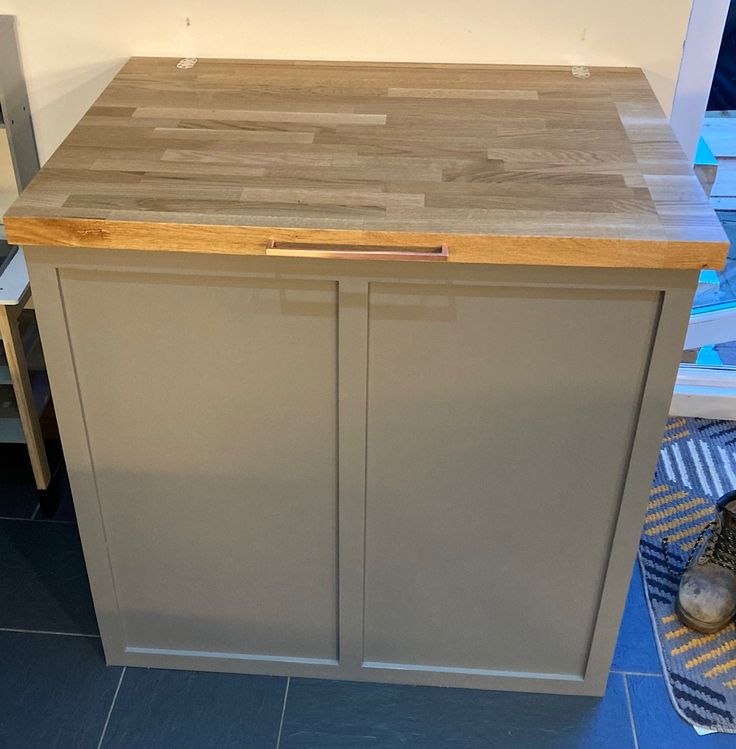 a wooden counter top sitting next to a tiled floor