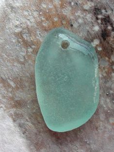 a green piece of glass sitting on top of snow