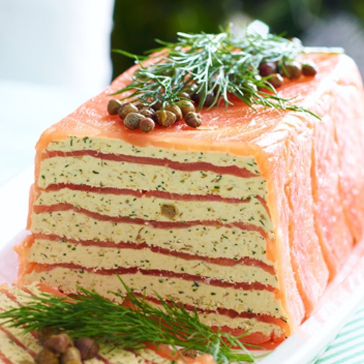 there is a large piece of cake on the plate with pine nuts and sprigs