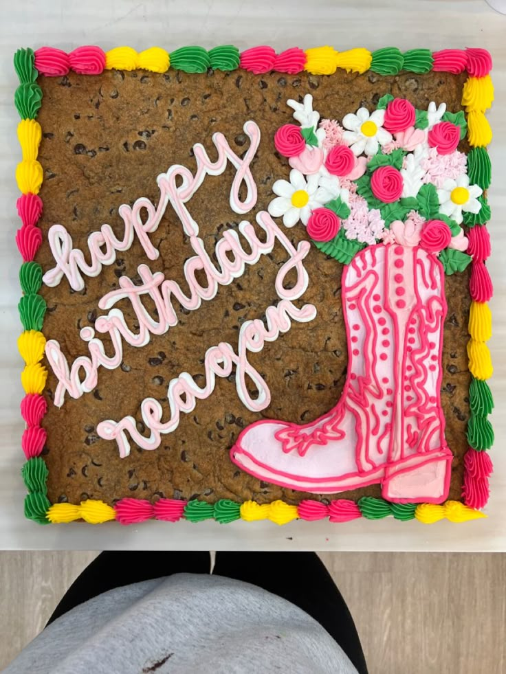 a decorated birthday cake with boots and flowers