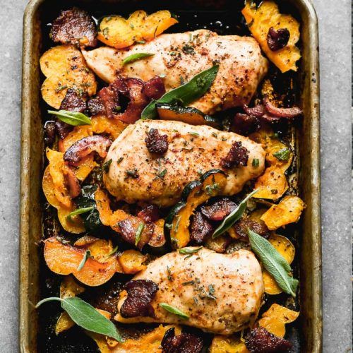 a pan filled with chicken and vegetables on top of a table